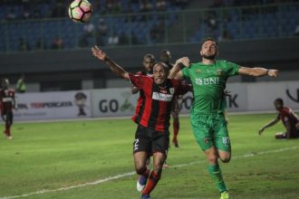 Pesepak bola Bhayangkara FC Ilija Spasojevic (kanan) berebut bola dengan pesepak bola Persipura Jayapura Rony Esar Beroperay (kiri), pada pertandingan Gojek Traveloka Liga 1 di Stadion Patriot Candrabaga, Bekasi, Jawa Barat, Sabtu (9/9).