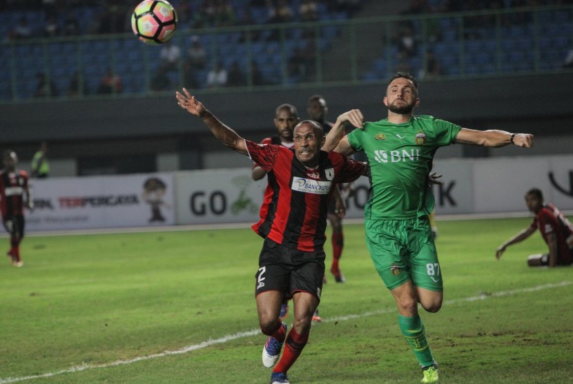 Pesepak bola Bhayangkara FC Ilija Spasojevic (kanan) berebut bola dengan pesepak bola Persipura Jayapura Rony Esar Beroperay (kiri), pada pertandingan Gojek Traveloka Liga 1 di Stadion Patriot Candrabaga, Bekasi, Jawa Barat, Sabtu (9/9).