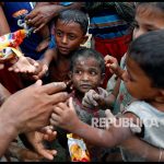 Bocah pengungsi Rohingya berbagi makanan setelah melintasi pesawahan setelah melintasi perbatasan Bangladesh-Myanmar di Teknaf, Bangladesh, Rabu (6/9).