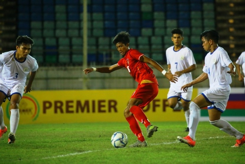 Pemain Myanmar (merah) membawa bola saat menghadapi Filipina pada Piala AFF U-18, Senin (11/9).