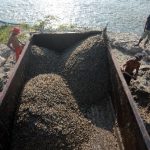 Pekerja sedang mengangkut pasir sebagai salah satu hasil pertambangan.