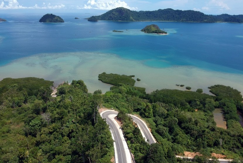 Foto udara kendaraan melintas di jalan akses wisata ke Nagari Mandeh, Pesisir Selatan, Sumatera Barat, Selasa (3/7).