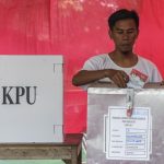 Warga memasukkan surat suara ke dalam kotak suara usai mencoblos pada pemilihan ulang Pilkada Banten di TPS 3 Babakan Asem, Teluk Naga, Tangerang, Banten, Minggu (19/2).
