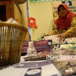 Peserta pameran Ekonomi Kreatif Rusunawa Jakarta (E-Kerja) menata hasil kerajinan ketika mengikuti pameran di Gedung Blok G, Balaikota Jakarta, Rabu (26/4).