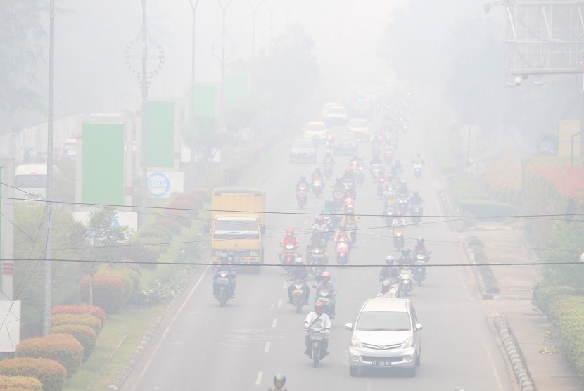 Sejumlah pengendara melintasi jalan yang diselimuti kabut asap di Pontianak, Kalimantan Barat, Senin (16/9/2019).