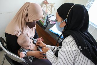 Dokter memeriksa kesehatan pasien bergejala Infeksi Saluran Pernapasan Akut (ISPA) (ilustrasi).
